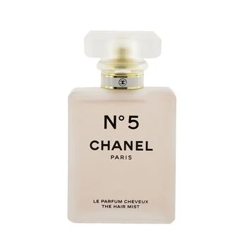 The frosted glass bottle of CHANEL No.5 The Hair Mist on a marble surface