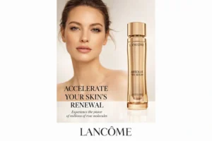 Iridescent Lancome Absolue The Serum in a luxe gold refillable glass bottle on a polished surface.