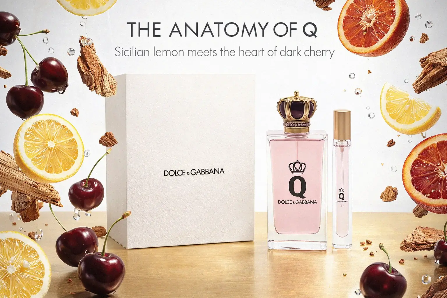 Dolce & Gabbana Q Eau de Parfum bottles with gold crown caps on a minimalist vanity.