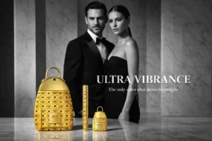 Gold backpack-shaped perfume bottles in different sizes arranged on a reflective surface.