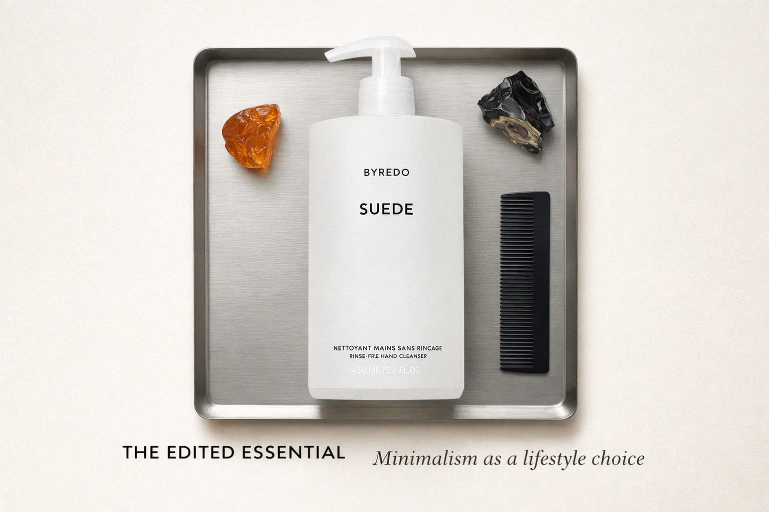 A minimalist Byredo Suede 450 ml velvet-matte white pump bottle on a marble bathroom vanity.