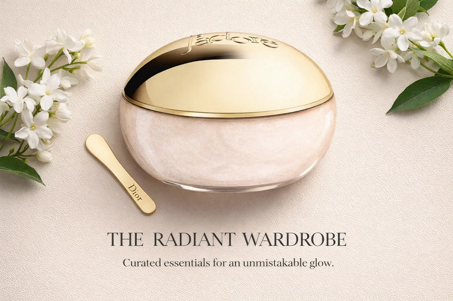 Round glass jar of Dior J'adore Shimmering Scrub with a gold cap on a polished bathroom shelf.