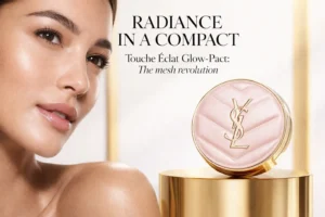 Pink faux-leather cushion compact with gold YSL chevron logo on white marble.