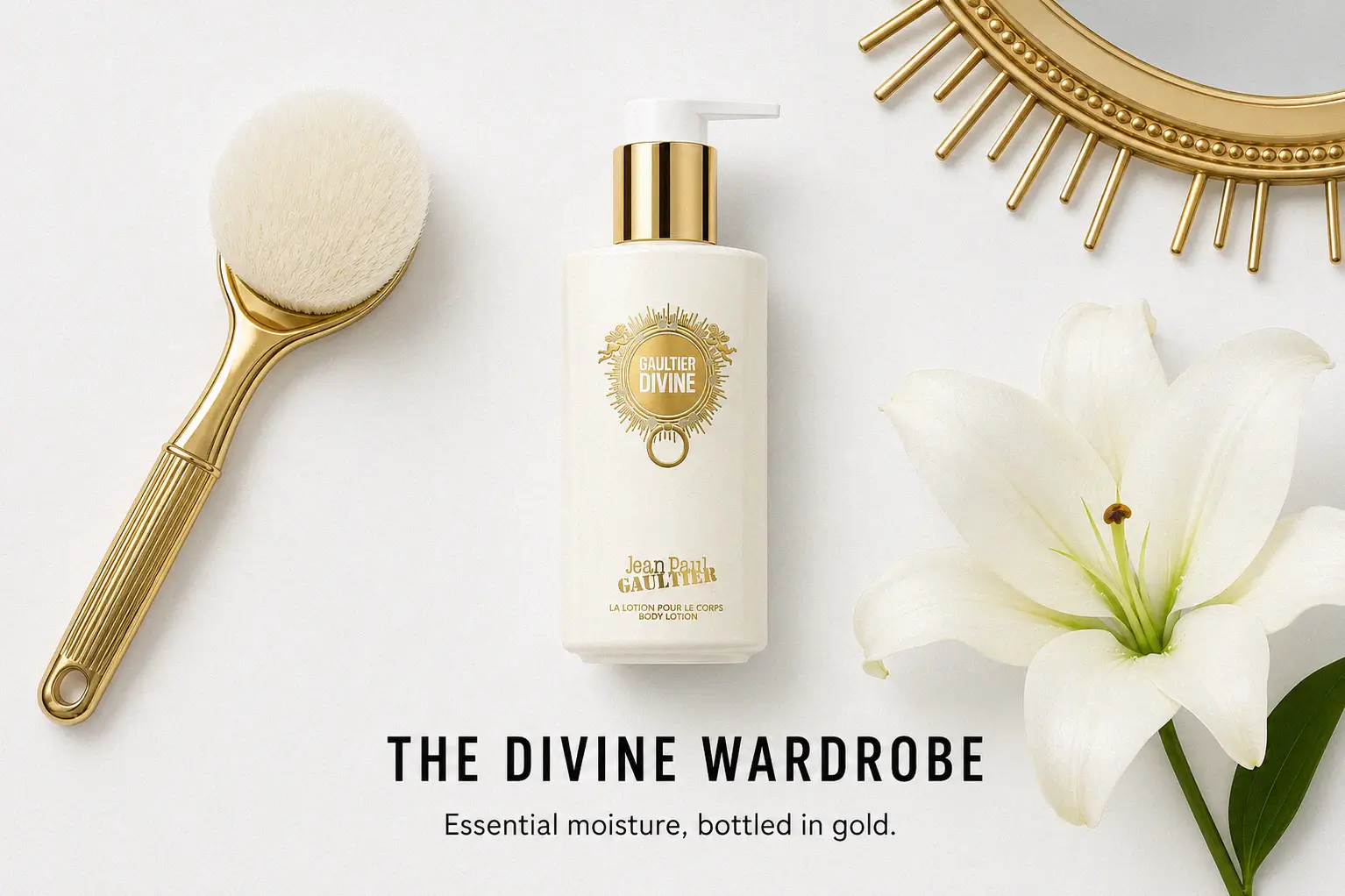 A white and gold tube of Jean Paul Gaultier Divine Body Lotion on a clean, luxury beauty vanity.