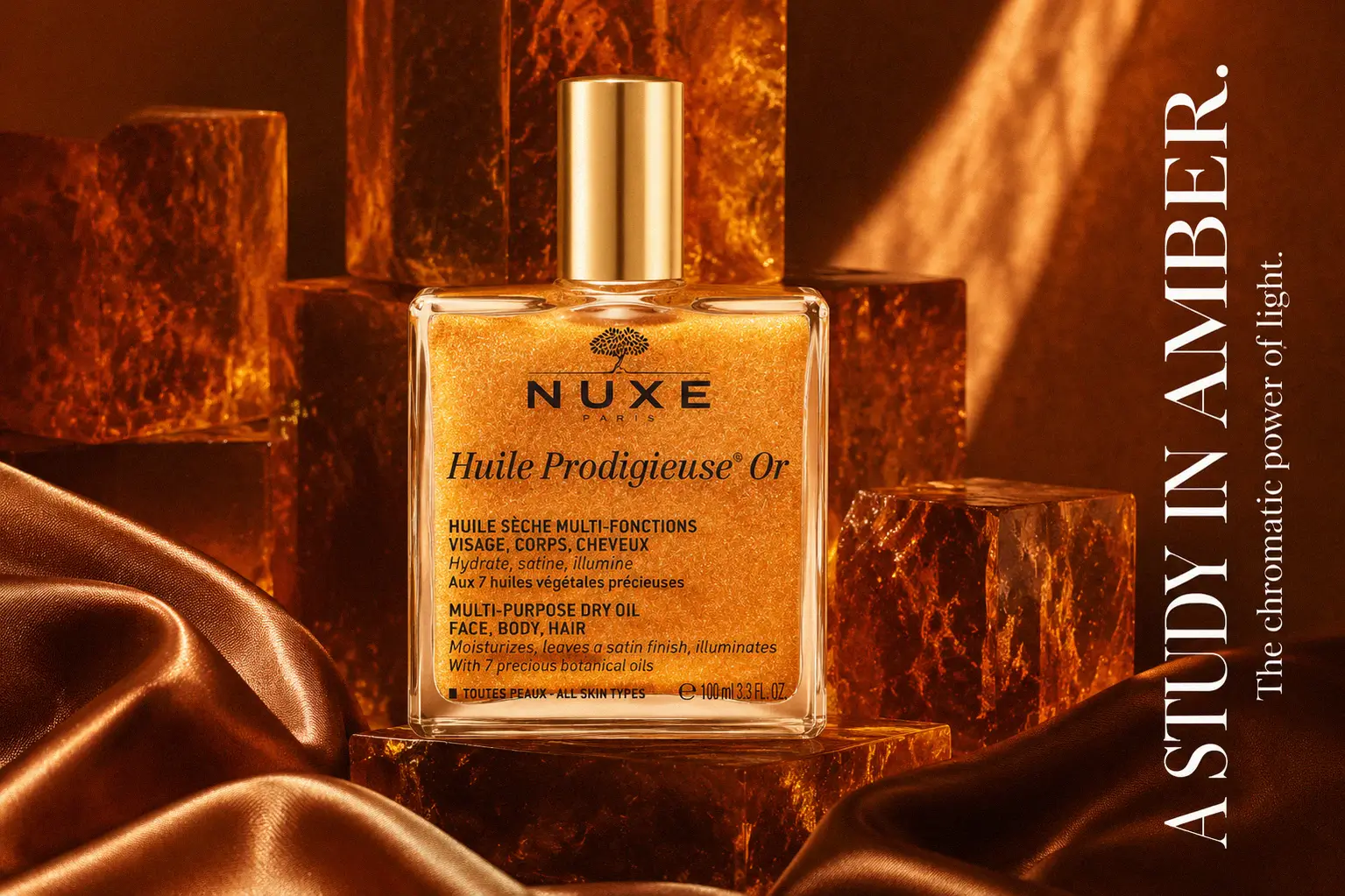 Square glass bottle of Nuxe Huile Prodigieuse Or showing shimmering golden dry oil with a gold cap.