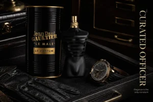 A black and gold lacquered torso-shaped bottle of Jean Paul Gaultier Le Male Le Parfum on a dark surface.
