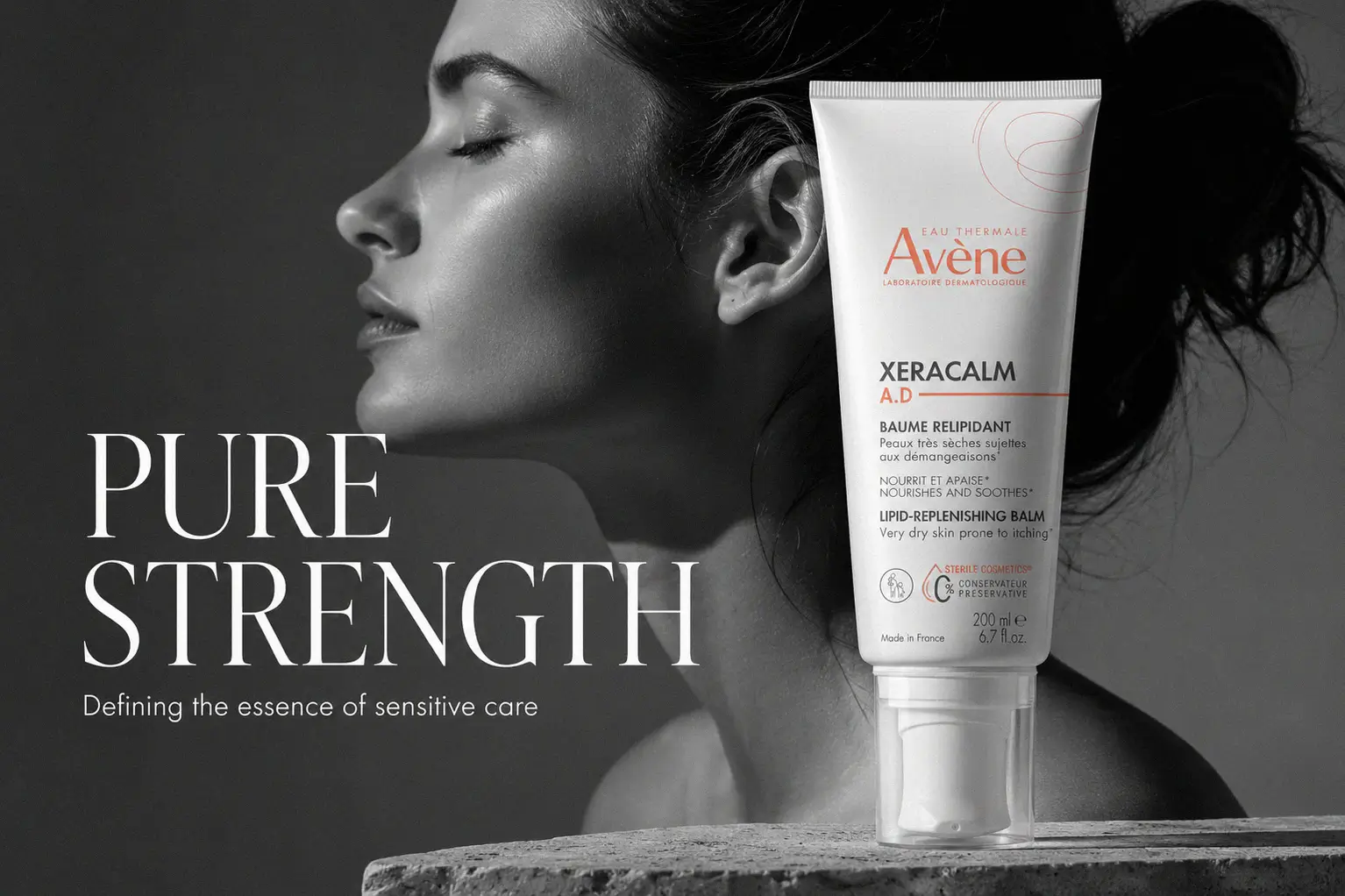 Large white bottle of Avene XeraCalm A.D balm with a sterile pump dispenser on a clean white surface.