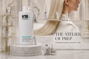 K18 Peptide Prep Pro Chelating Hair Complex spray bottle on a minimalist white bathroom shelf.