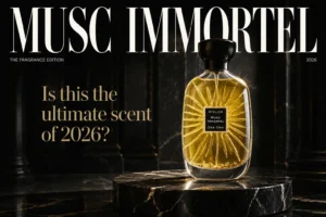 Clear glass perfume bottle with gold flakes inside and a black cap on a neutral background.