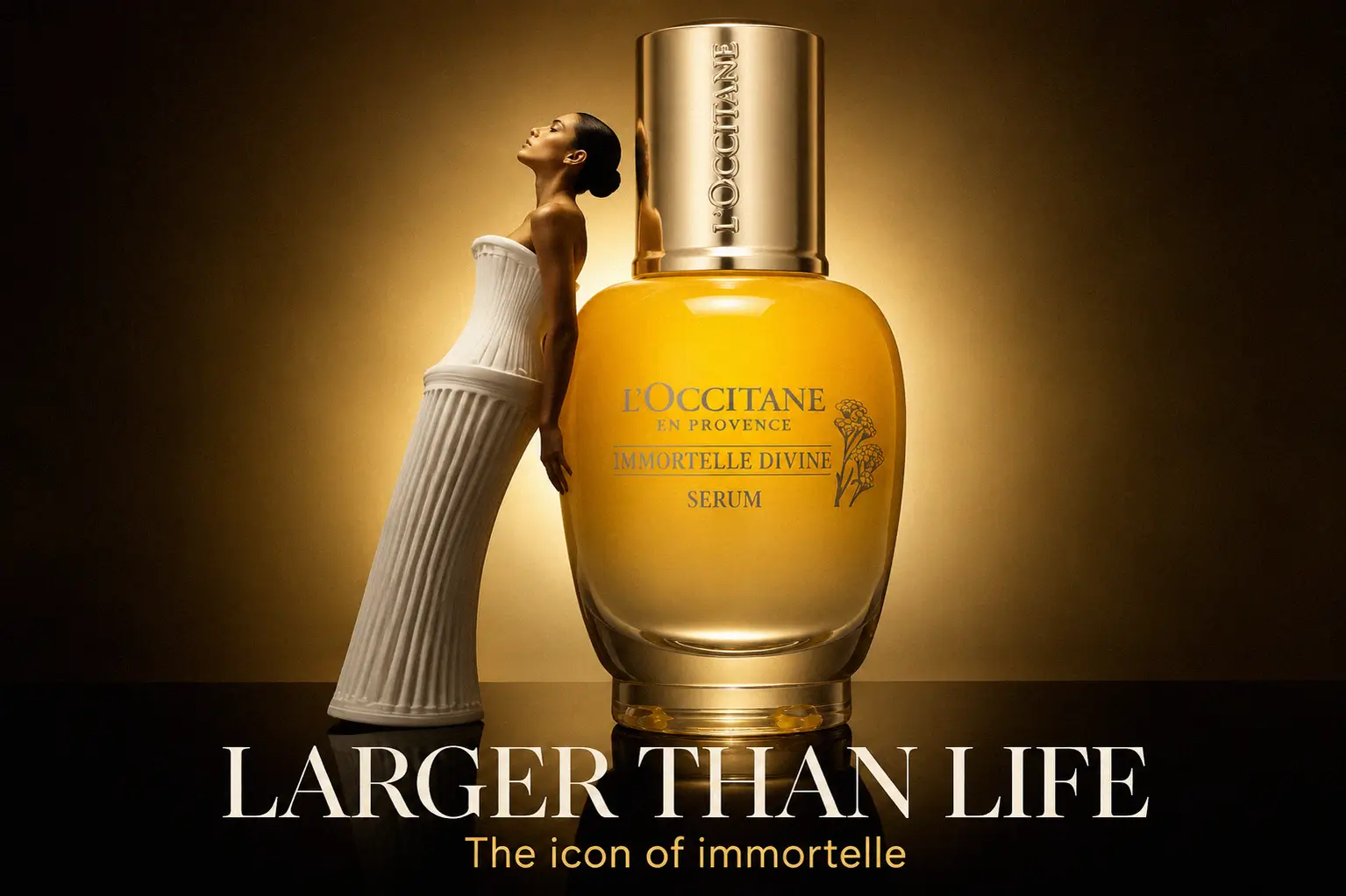 A gold L'Occitane Immortelle Divine Serum bottle on a white marble surface with soft floral accents.