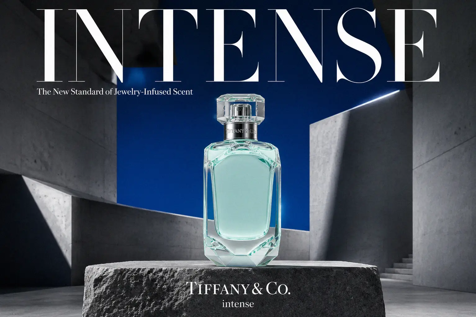 A faceted glass Tiffany & Co. Intense perfume bottle with silver detailing on a white background.